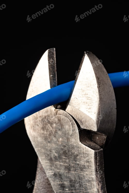 Preview: Cutting a blue electrical wire with pliers in a dark setting
