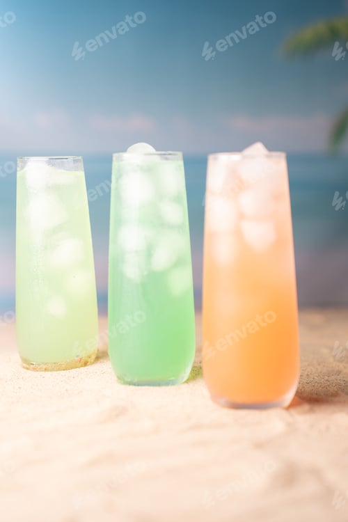 Preview: Vibrant pastel cocktails on sandy beach; refreshing, tropical, sunlit glow of translucent glasses.