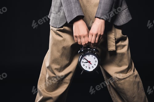 Preview: cropped shot of stylish woman holding clock isolated on black