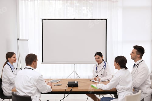 Preview: Team of doctors using video projector during conference indoors