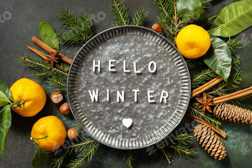 Preview: Hello winter text. Winter composition with fir branches, cones and tangerines.