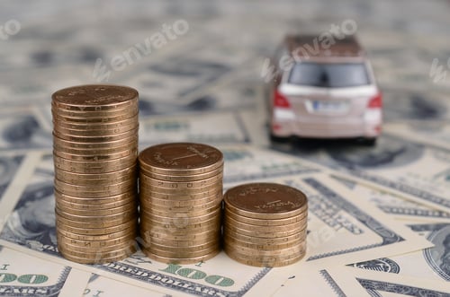 Preview: Toy car model at the stacks of golden coins lies on many dollar bills