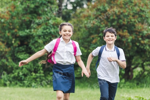 Preview: happy schoolchildren with backpacks running by park