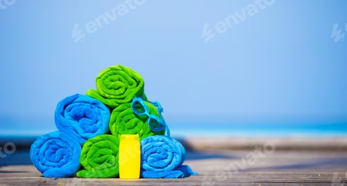 Preview: Beach and summer vacation accessories concept - close-up of colorful towels, swimming goggles and