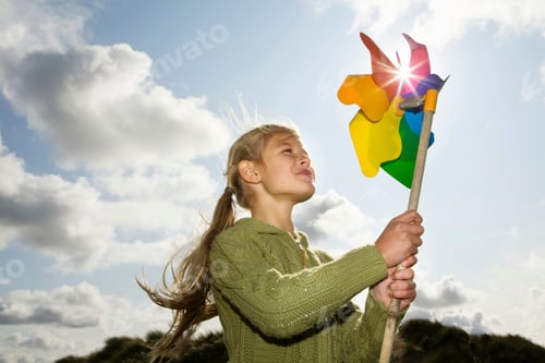Preview: Young girl enjoying the outdoors with a colorful pinwheel on a sunny day