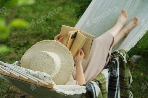 Preview: Harmony in a backyard haven a woman, a book, a hammock. A tranquil snapshot of slow living, a joyful