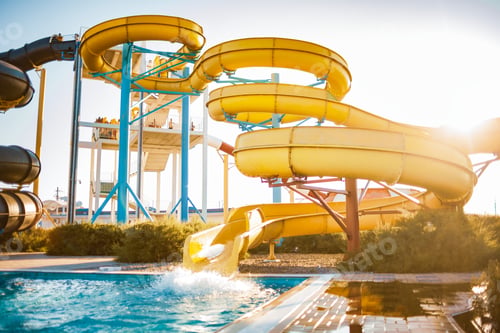 Preview: An woman descended from a slide into a pool with transparent water