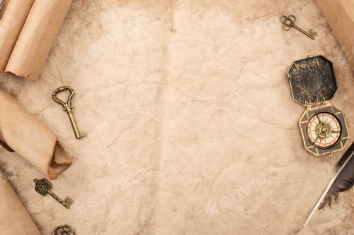 Preview: top view of vintage keys and compass near feather on aged paper