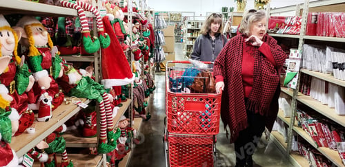 Preview: Baby boomer confident women holiday shopping for Christmas gifts in retail store together.
