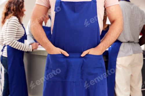 Preview: Close Up Of Man With Hands In Apron Pocket Taking Part In Cookery Class In Kitchen