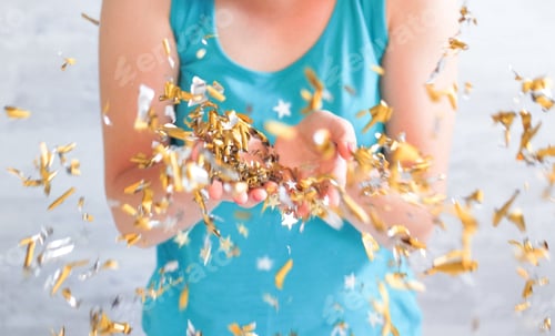 Preview: Girl blowing golden colored confetti