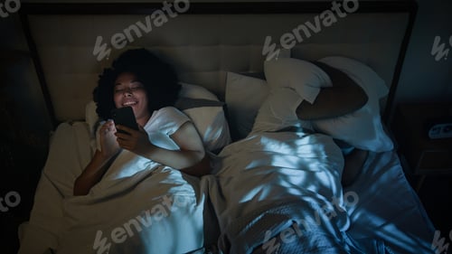 Preview: African American gadget addict social media phone addiction woman using smartphone in bed night