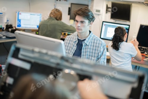 Preview: A man seated at a computer, in a repair shop.