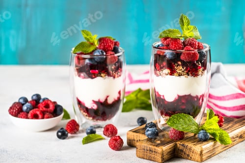 Preview: Parfait with granola, jam and fresh berries in the glass jar.