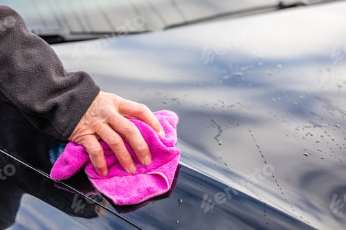 Preview: Closeup of a male hand washing a car with a pink rag