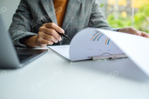Preview: Businesswoman working on business paperwork and laptop computer in office