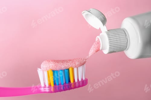Preview: Applying paste on toothbrush against color background, closeup