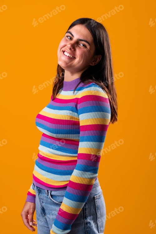 Preview: Young woman smiling and showing her colorful style in studio portrait