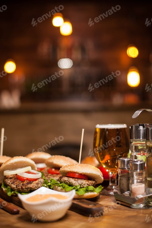 Preview: Close-up of delicious fresh home made burgers with lettuce, cheese and tomato with white sauce on a