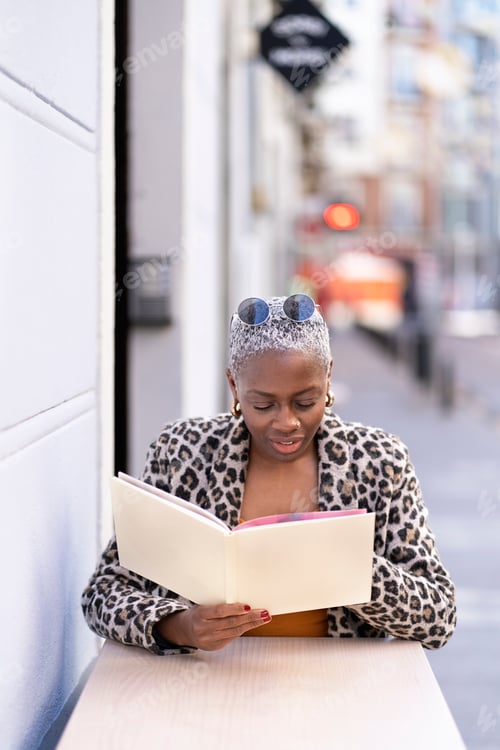 Preview: Black woman reading letter from cafe