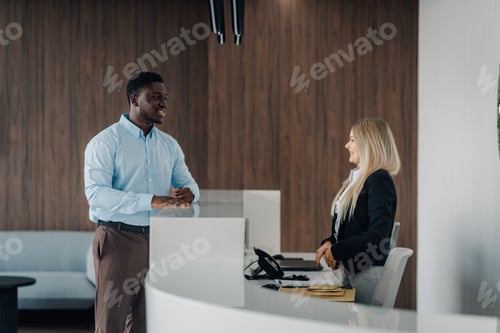 Preview: Man talking to female receptionist at office front desk