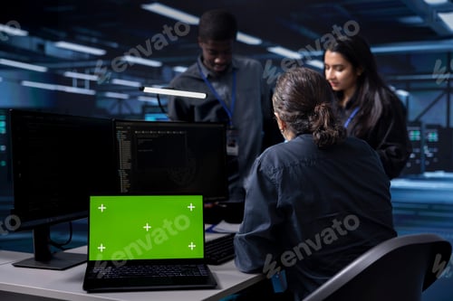 Preview: Diverse staff members working on mockup laptop to prevent server farm damages