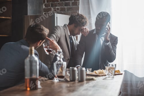 Preview: multiethnic men in suits drinking alcohol and talking by smartphone