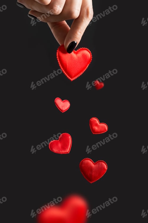 Preview: Valentine's Day card. Woman holding red flying hearts on black.
