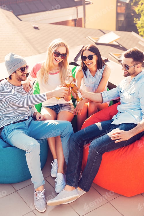 Preview: Enjoying Beer With Friends. Top View Of Four Young Cheerful People Cheering With Beer And Smiling
