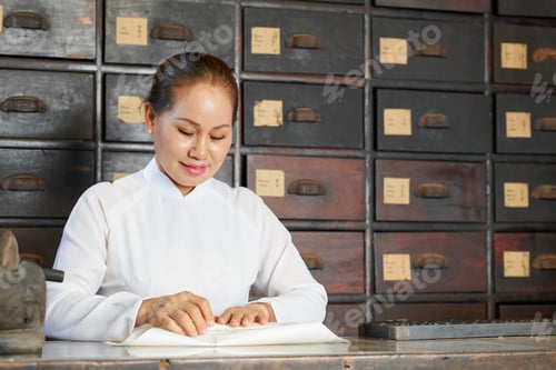 Preview: Chinese medicine practitioner wrapping dry roots and mushrooms