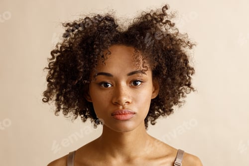Preview: Attractive multiracial female posing at camera over beige background