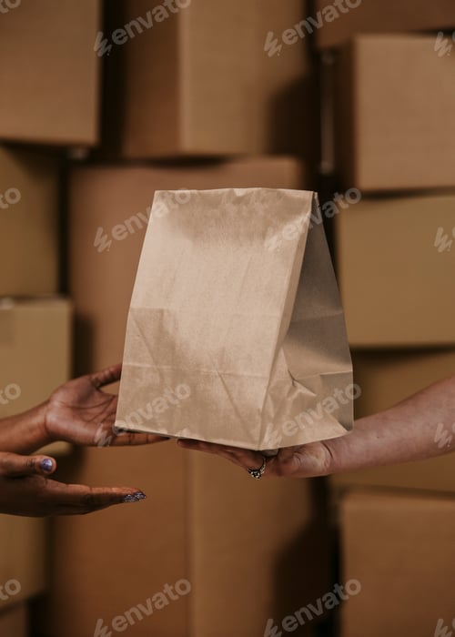 Preview: Delivery man handling paper bag to customer