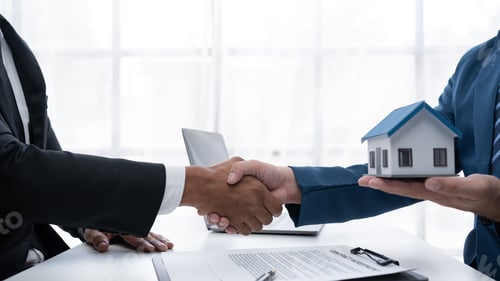 Preview: Real estate agent shakes hands with a client to sign a home purchase contract congratulating