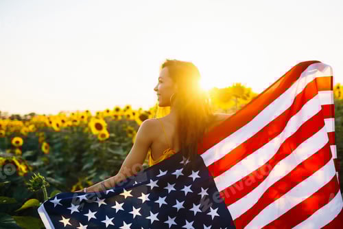 Preview: Woman proudly hold waving american USA flag in in the sunflower field. Independence Day, 4th July.