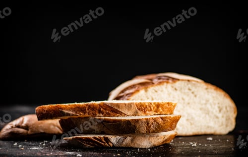 Preview: Sliced wheat bread. On a black background.