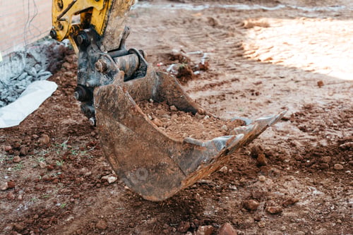 Preview: Shovel machine on construction site with worker working with pneumatic hammer on background