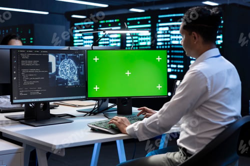Preview: Employee solving tasks on mockup PC in server hub used for AI deep learning