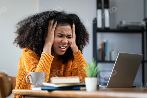 Preview: Stressed black woman focusing on work using laptop at home office