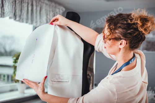 Preview: Tailor measuring lady jacket on mannequin at fashion design workshop