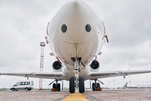 Preview: Front view. Turboprop aircraft parked on the runway at daytime
