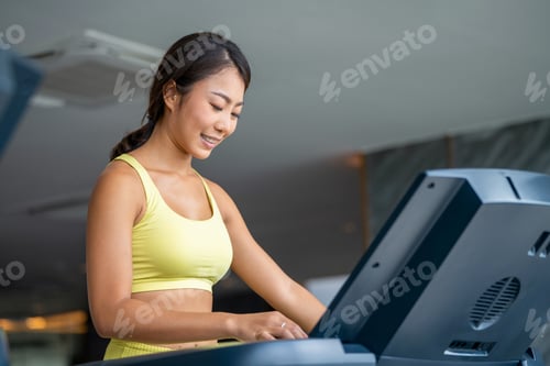 Preview: Attractive young running sports woman is working out in gym. Doing cardio t