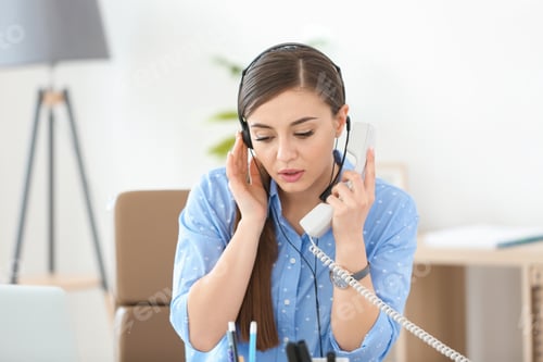 Preview: Young woman talking on phone through headset at workplace