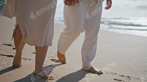 Preview: Pair legs walking beach near ocean waves closeup. Pregnant couple relaxing sea
