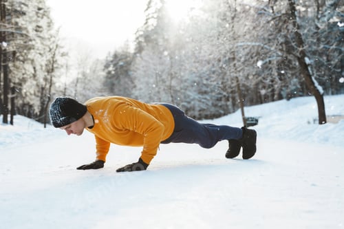 Preview: Athletic man doing push ups during his calisthenics winter workout