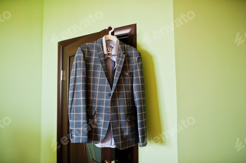 Preview: Awesome groom's clothing is hanging on the wall before the wedding ceremony.