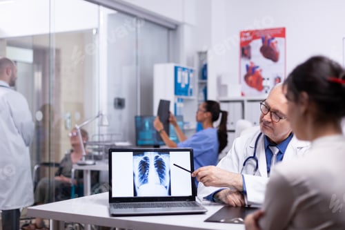 Preview: Doctor and nurse analising x-ray of patient