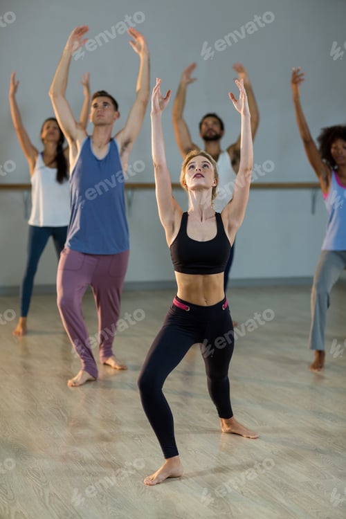 Preview: Group Of People Performing Stretching Exercise In Fitness Studio