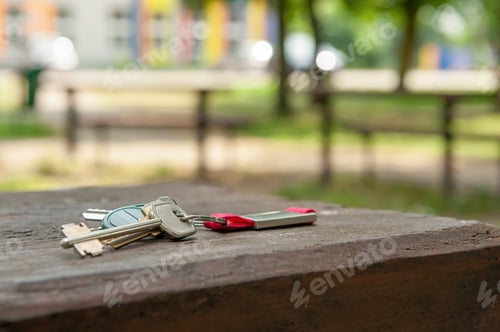 Preview: Keys forgotten on wooden bench outdoors, space for text. Lost and found