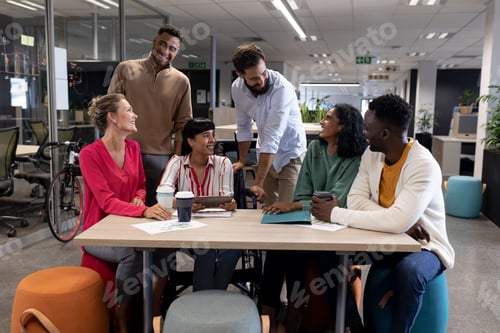 Preview: Happy multiracial male and female advisors discussing together during meeting in boardroom