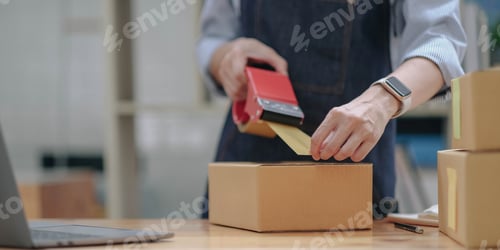 Preview: Close up online business owner prepares product for delivery to the customer.